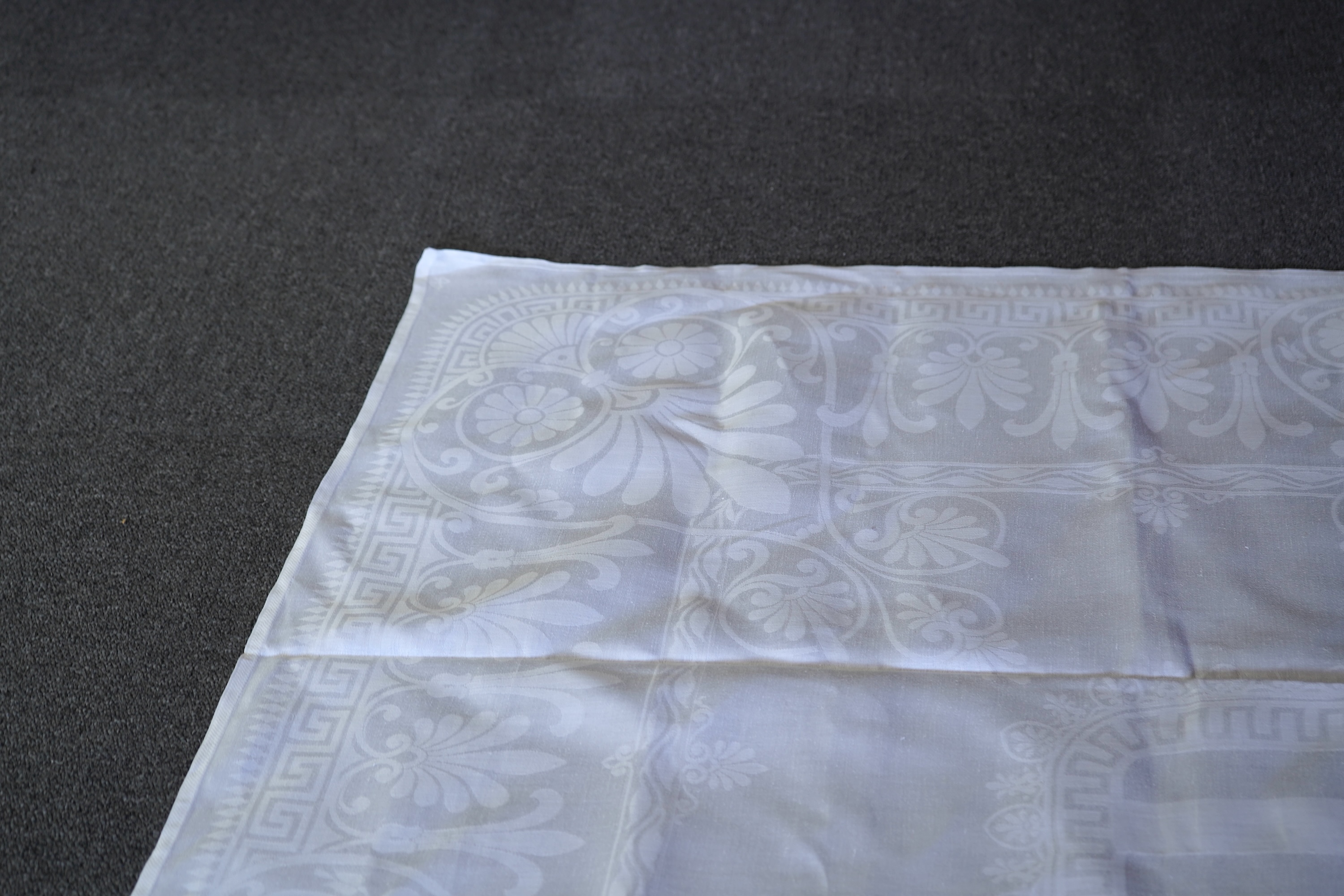 A late 19th century large white Irish damask table cloth, woven with an all over Christopher Dresser ‘inspired’ design. The overall design incorporating many of his known stylistic design motifs. Each corner has a shamro